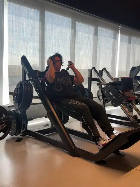 Daniel all'hack squat alla Venom Gym, con la luce del pomeriggio dalle vetrate